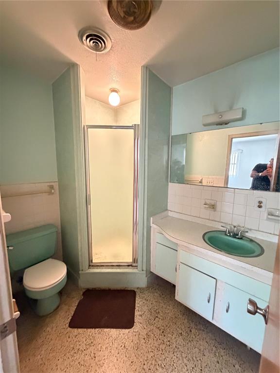A bathroom features a mint green toilet and vanity sink, a shower stall, and tiled walls — 4506 NE 11TH STREET, OCALA, FL