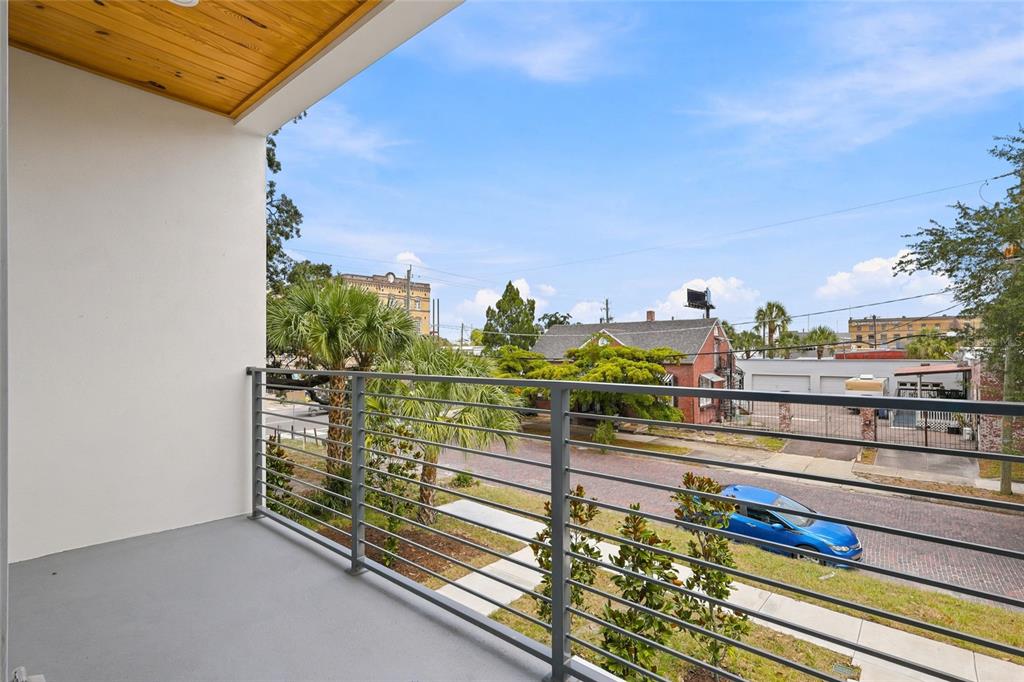 A balcony with a gray floor and metal railing overlooks a street and neighborhood buildings — 2138 W NASSAU STREET UNIT 2, TAMPA, FL