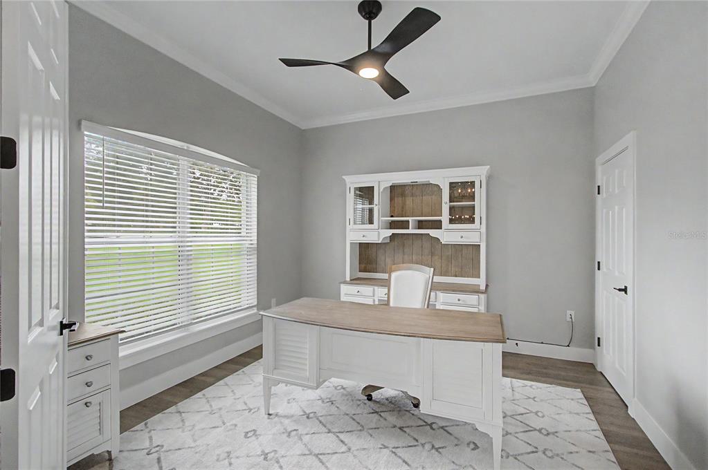 A home office features a white desk, a matching hutch, and a ceiling fan — 12913 COUNTY ROAD 104B, OXFORD, FL