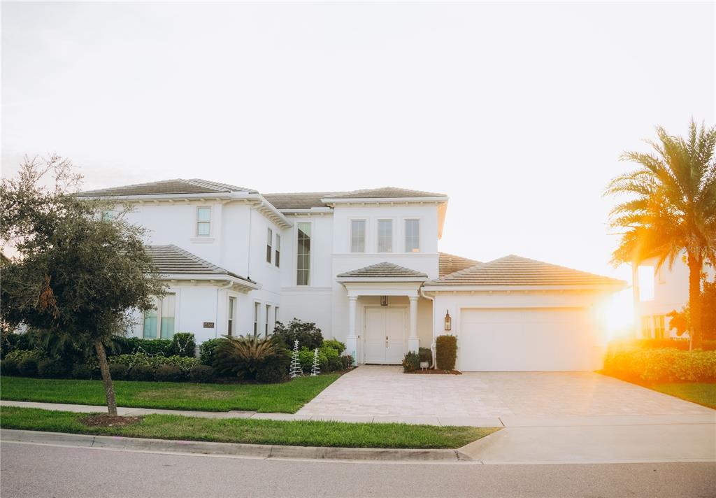 A two-story white house with a tiled roof, a paved driveway, and a two-car garage — 15505 SHOREBIRD LANE, WINTER GARDEN, FL