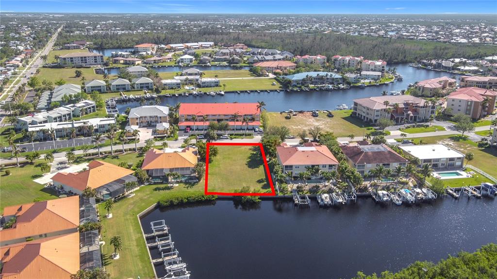 An aerial view shows a vacant rectangular waterfront lot outlined in red — 3227 PURPLE MARTIN DRIVE, PUNTA GORDA, FL
