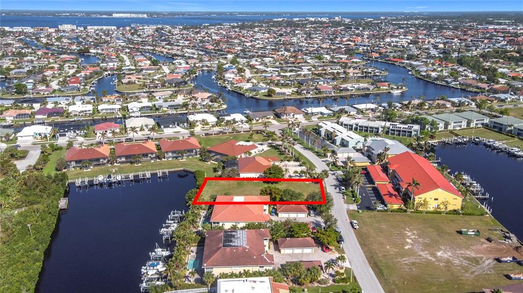 An aerial view shows a vacant rectangular lot outlined in red near a waterfront — 3227 PURPLE MARTIN DRIVE, PUNTA GORDA, FL