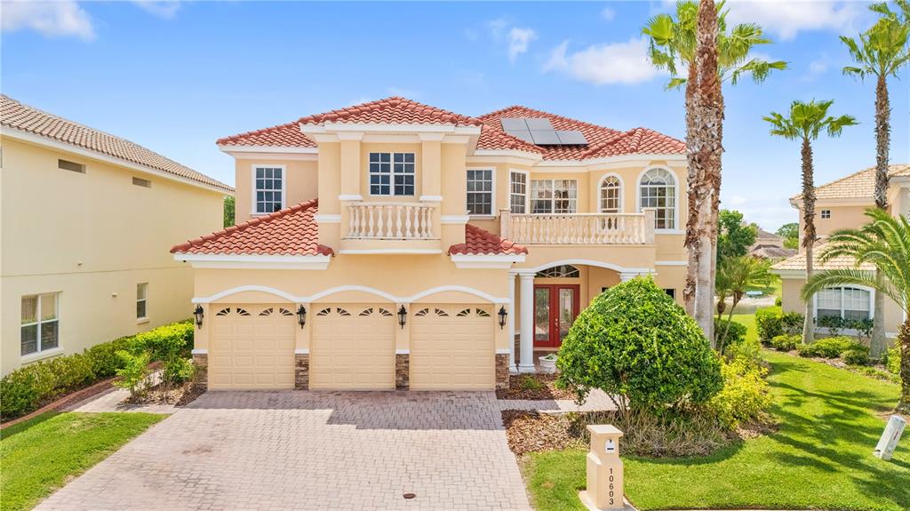 A two-story stucco house with a red tile roof and a three-car garage — 10603 CAYMAN ISLE COURT, TAMPA, FL