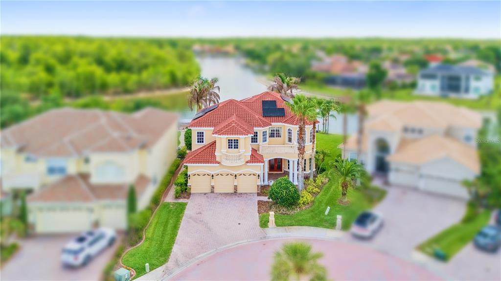 An aerial view of a two-story house with a red tile roof and three-car garage — 10603 CAYMAN ISLE COURT, TAMPA, FL