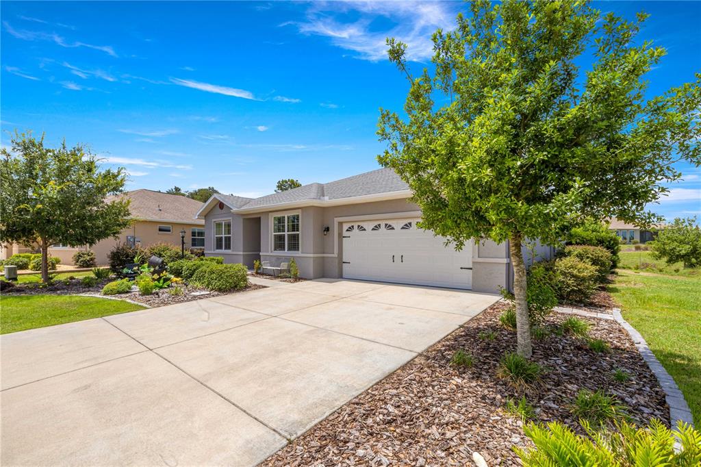 A single-story house with a concrete driveway, a two-car garage, and a landscaped front yard — 8847 SW 104TH CIRCLE, OCALA, FL