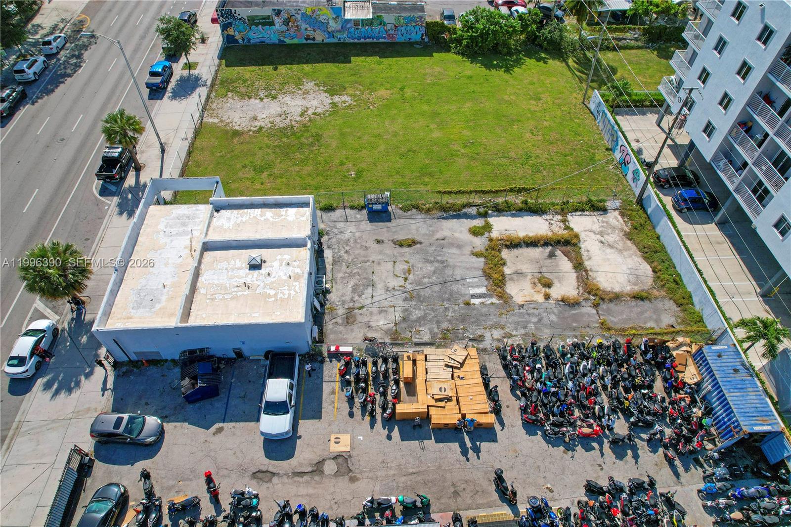 An aerial view shows a commercial building, a large vacant lot, and a motorcycle parking area — 727 W Flagler St, Miami FL 33130, MIAMI, FL