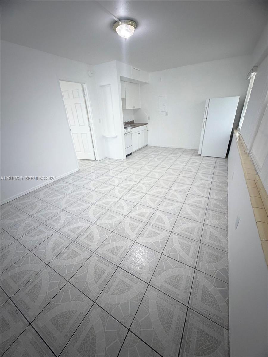 This kitchen features white cabinets, a white refrigerator, and light-colored patterned tile flooring — 2736 SW 22nd STREET # 2, Miami FL 33133, MIAMI, FL