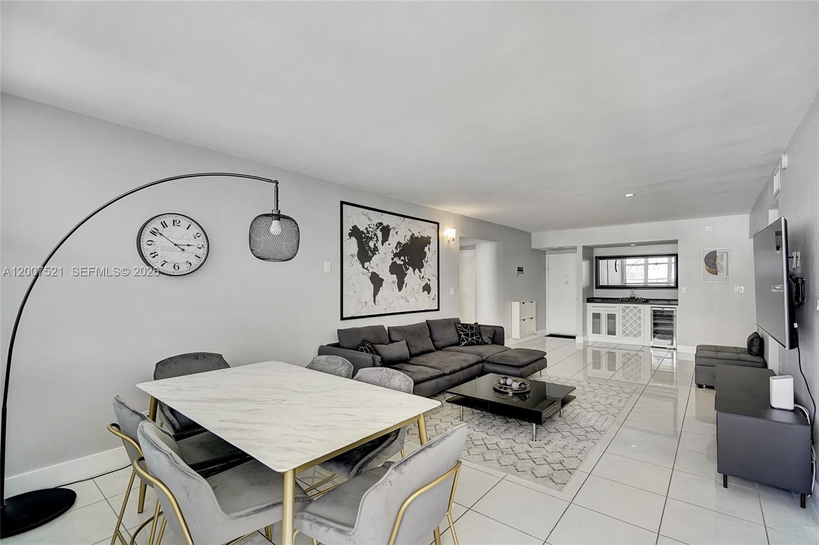 A modern living and dining area features white tile floors, a gray sectional, and marble table — 3725 S Ocean Dr # 1519, Hollywood FL 33019, HOLLYWOOD, FL
