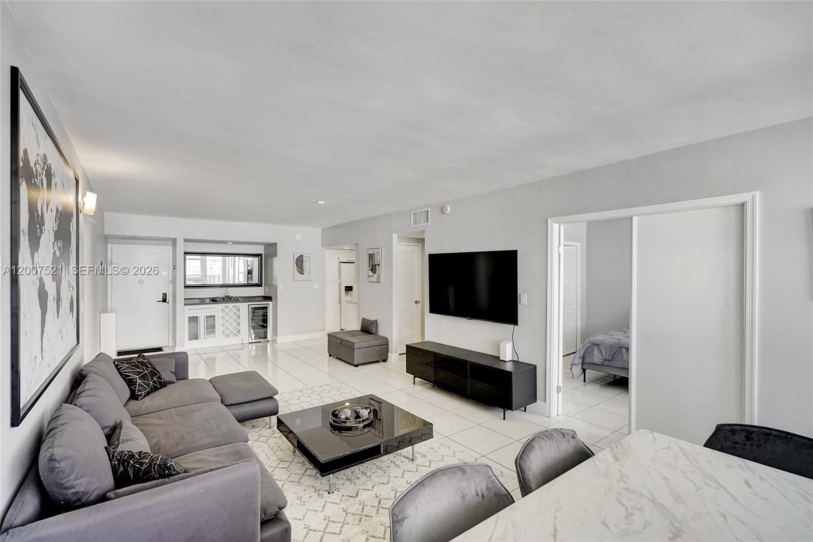 A modern living room features a grey sectional sofa, a black coffee table, and tile flooring — 3725 S Ocean Dr # 1519, Hollywood FL 33019, HOLLYWOOD, FL