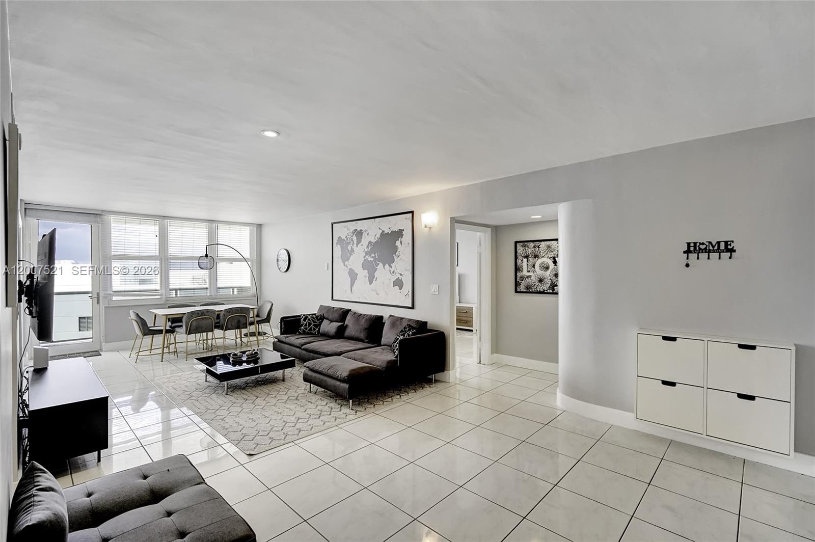 A living room with white tile floors, a grey sectional sofa, and a dining area — 3725 S Ocean Dr # 1519, Hollywood FL 33019, HOLLYWOOD, FL