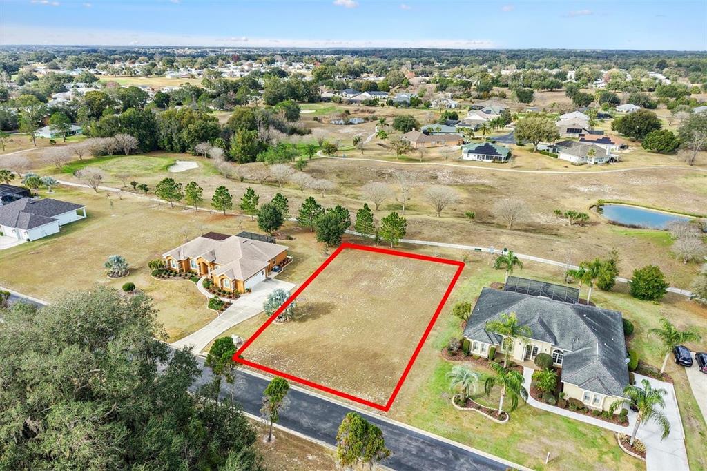 An aerial view shows a vacant rectangular residential lot outlined in red between two houses — 529 DOWLING CIRCLE, LADY LAKE, FL