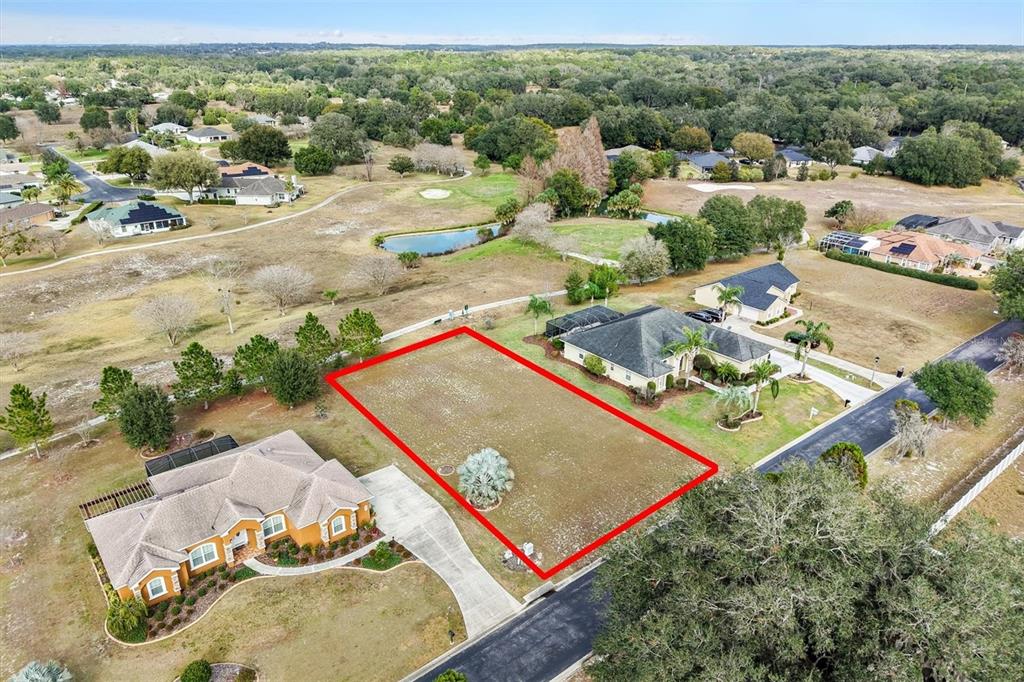 An aerial view shows a vacant rectangular lot outlined in red between two houses — 529 DOWLING CIRCLE, LADY LAKE, FL