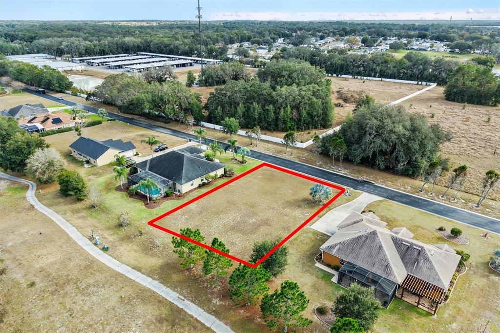 An aerial view shows a vacant rectangular residential lot outlined in red between two houses — 529 DOWLING CIRCLE, LADY LAKE, FL
