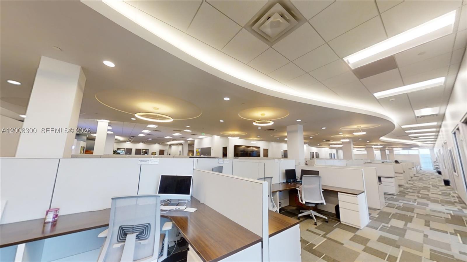 This office space features rows of cubicles with wooden desks and a curved ceiling design — 1501 Biscayne Blvd, Miami FL 33132, MIAMI, FL