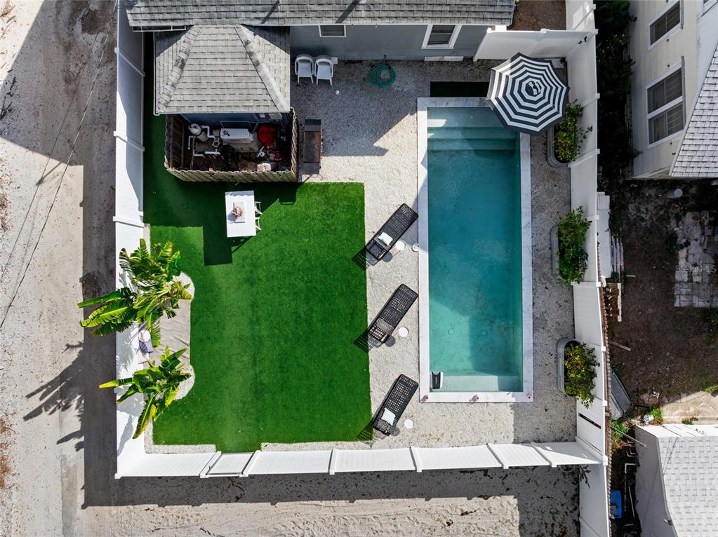 An aerial view shows a backyard with a rectangular pool, lounge chairs, and artificial turf — 783 30TH AVENUE N, ST PETERSBURG, FL