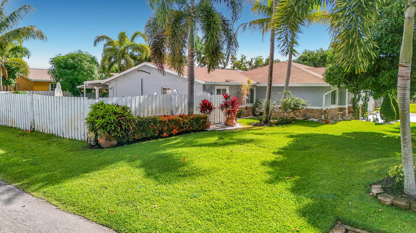 A single-story house with a white fence, palm trees, and a green lawn — 3119 Indian Trail, Lake Worth FL 33462, LAKE WORTH, FL