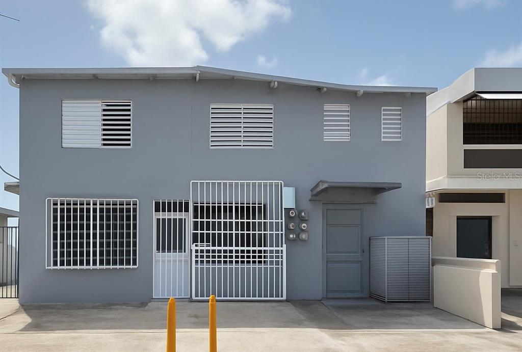 A two-story gray building exterior features white security bars on windows and doors — A13 GALICIA AVE.,, CAROLINA, PR
