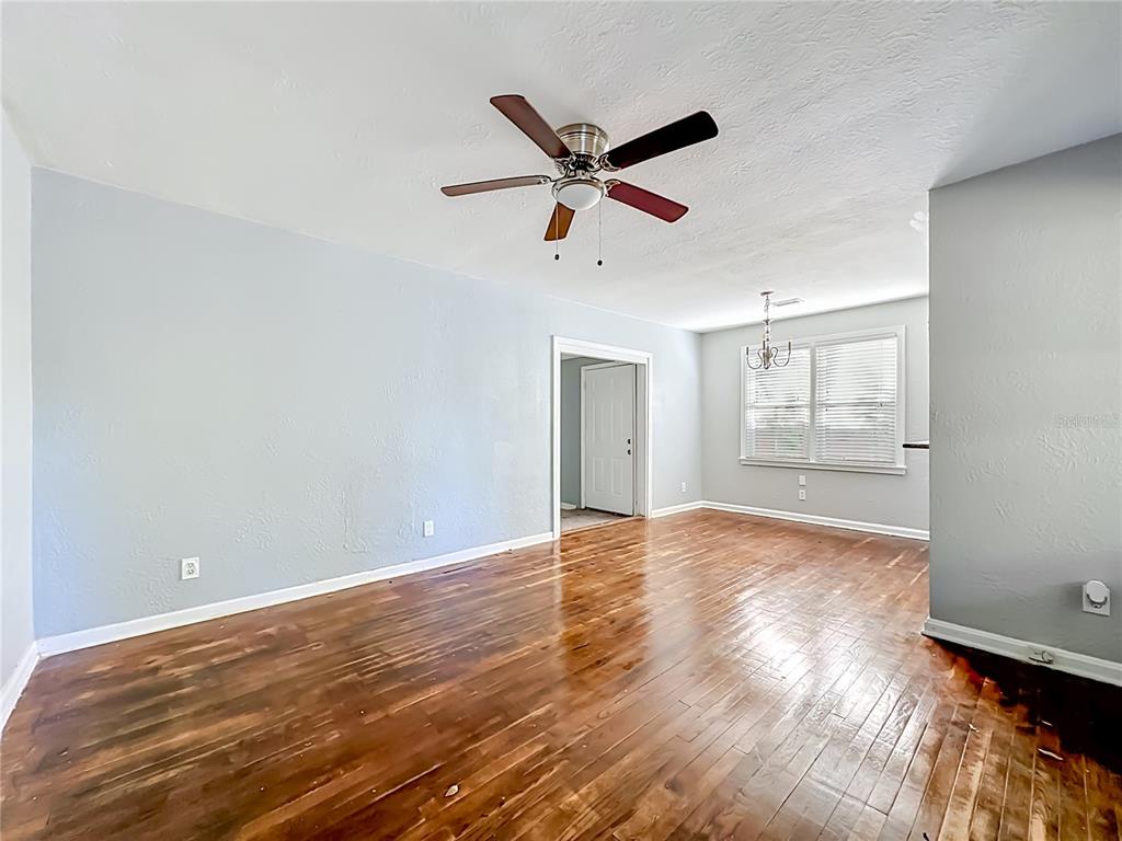 A spacious room features light blue walls, dark hardwood flooring, and a ceiling fan — 3323 POST STREET, JACKSONVILLE, FL