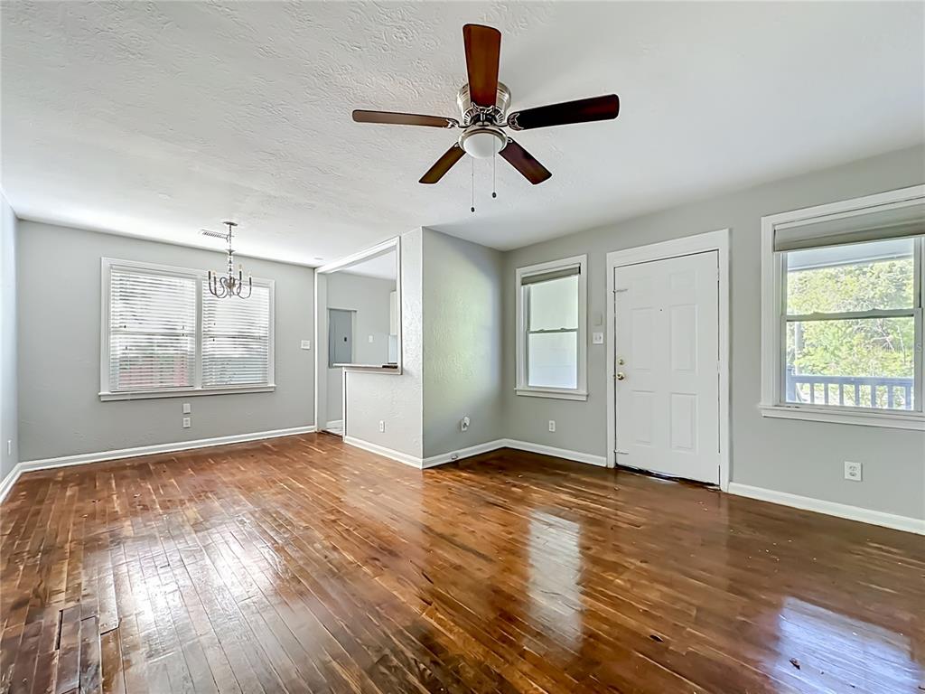 A living room features hardwood floors, a ceiling fan, and a white front door — 3323 POST STREET, JACKSONVILLE, FL