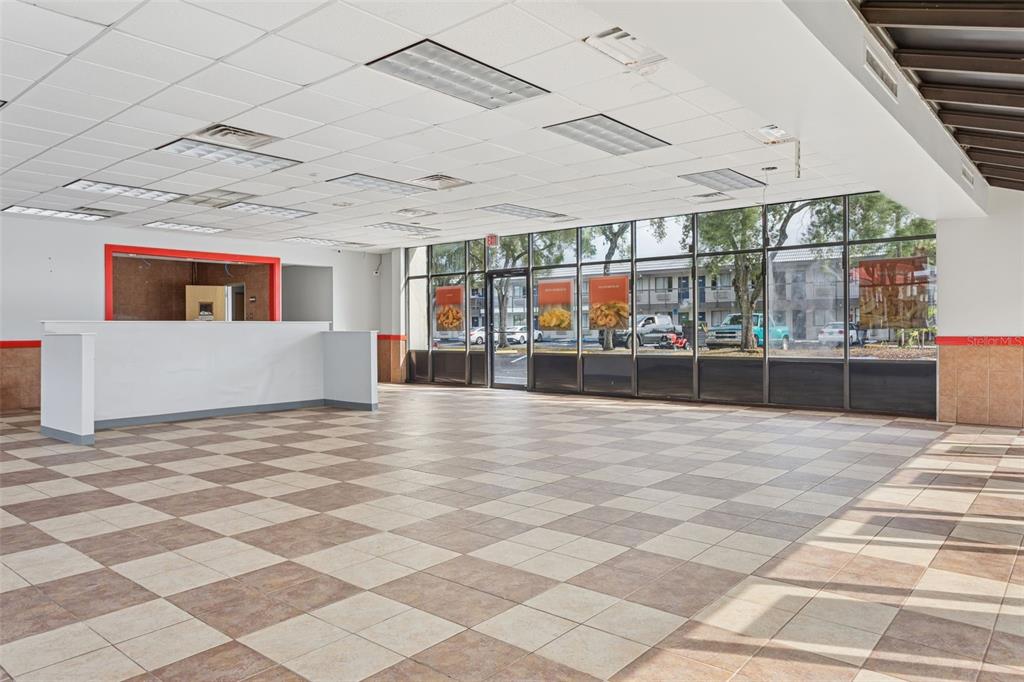 An empty commercial space features a checkered tile floor, a service counter, and large windows — 6620 E DR MARTIN LUTHER KING JR BOULEVARD, TAMPA, FL
