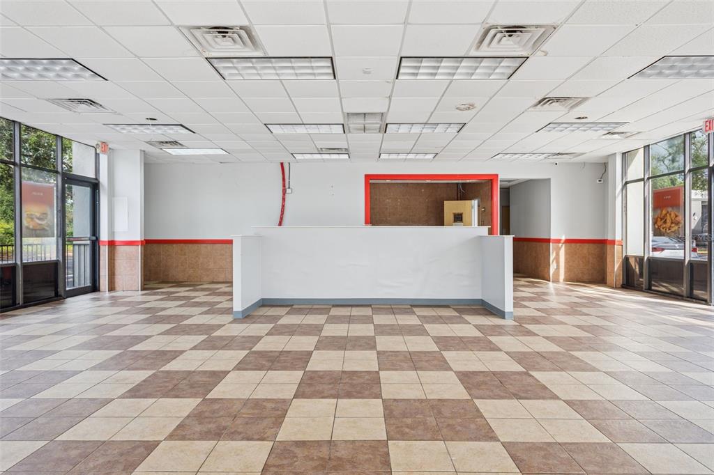An empty commercial space features a checkered tile floor, drop ceiling, and a central counter — 6620 E DR MARTIN LUTHER KING JR BOULEVARD, TAMPA, FL