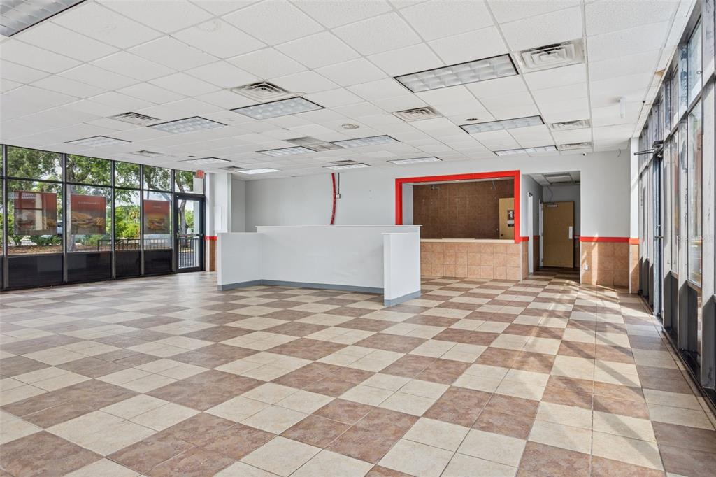 An empty commercial space features a checkered tile floor, drop ceiling, and a service counter — 6620 E DR MARTIN LUTHER KING JR BOULEVARD, TAMPA, FL