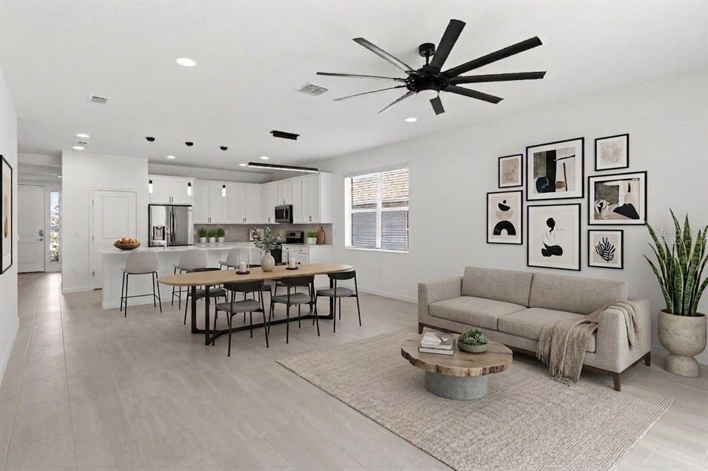 A modern open-concept living and dining area with white cabinets, light flooring, and a ceiling fan — 413 SAPPHIRE DRIVE, DAVENPORT, FL