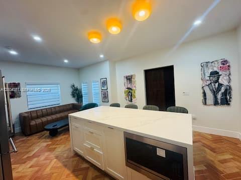 A kitchen island with a white countertop sits in a room with herringbone wood floors — 905 SW 13th Ct # 905, Miami FL 33135, MIAMI, FL