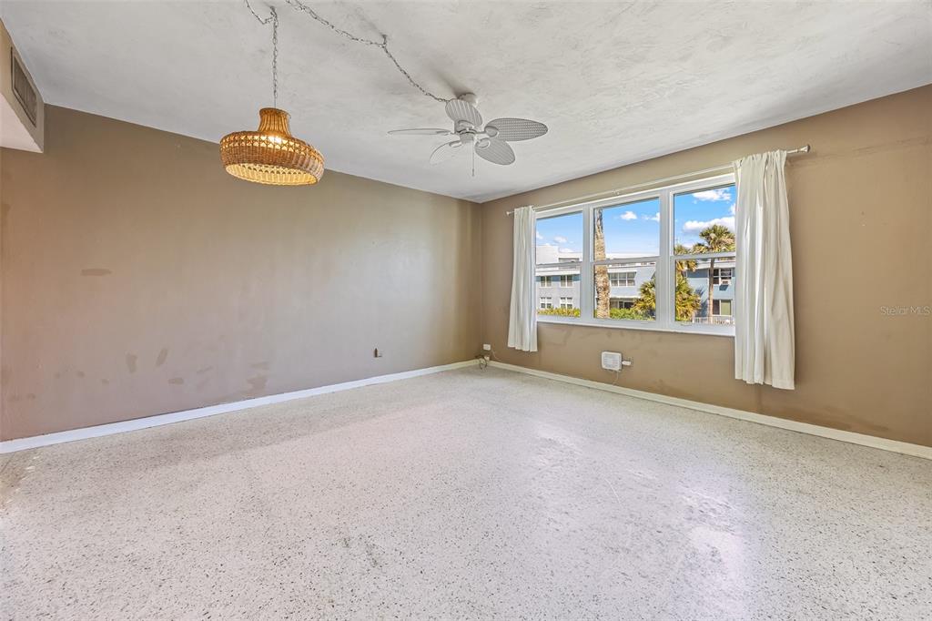 A living room features a beige sofa, two rattan chairs, a coffee table, and a television — 55 SEA PARK BOULEVARD UNIT 309, SATELLITE BEACH, FL