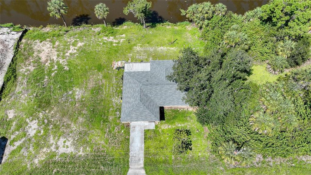 An aerial view shows a house with a gray roof situated on a grassy lot — 351 & 359 KINDRED BOULEVARD, PORT CHARLOTTE, FL
