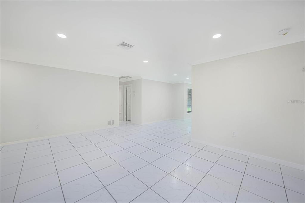 An empty room with white tiled floors, recessed lighting, and plain white walls — 351 & 359 KINDRED BOULEVARD, PORT CHARLOTTE, FL