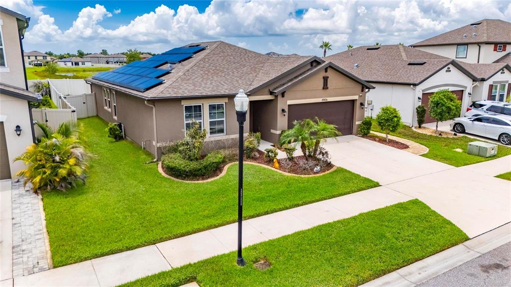 A single-story suburban house with a brown exterior, solar panels, and a two-car garage — 11906 BAHIA VALLEY DRIVE, RIVERVIEW, FL
