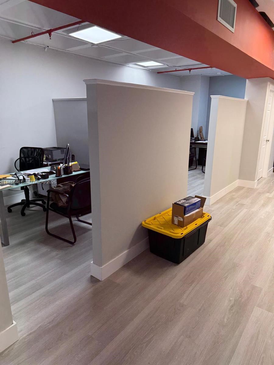 An office space features two partitioned cubicles with light wood-look flooring and recessed ceiling lights — 4300 Biscayne Blvd # G06, Miami FL 33137, MIAMI, FL
