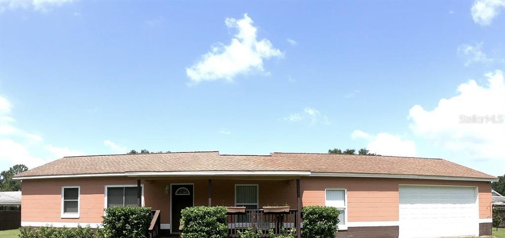 A single-story house with peach-colored siding, a covered front porch, and an attached garage — 1316 GRAYSON DRIVE, ORLANDO, FL