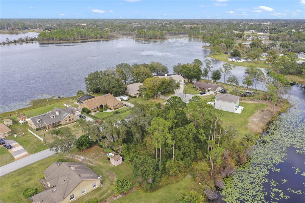 An aerial view shows several houses situated on a peninsula surrounded by a lake — 2145 MONTECITO AVENUE, DELTONA, FL