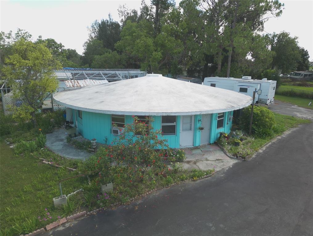 An aerial view of a round, teal-colored house with a large, flat, circular roof — 1603, 1605,1608,1611 W SHELL POINT ROAD, RUSKIN, FL
