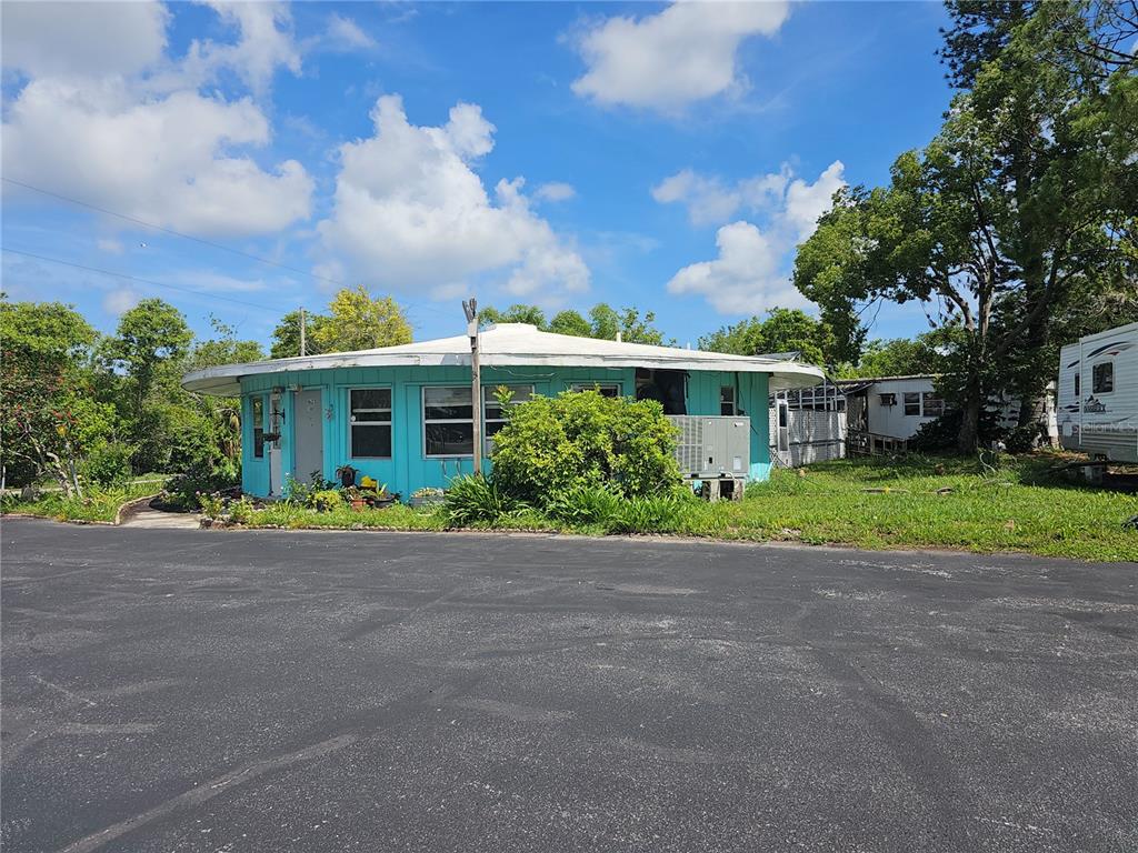 A round, turquoise-colored house with a flat roof sits next to a paved parking lot — 1603, 1605,1608,1611 W SHELL POINT ROAD, RUSKIN, FL