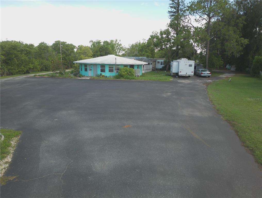 An aerial view shows a turquoise house with a large asphalt driveway and a trailer — 1603, 1605,1608,1611 W SHELL POINT ROAD, RUSKIN, FL