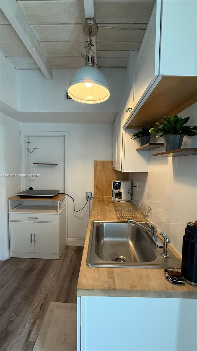 A small kitchen features a stainless steel sink, butcher block countertops, and white cabinetry — 115 SE 2nd St # 2, Dania Beach FL 33004, DANIA BEACH, FL