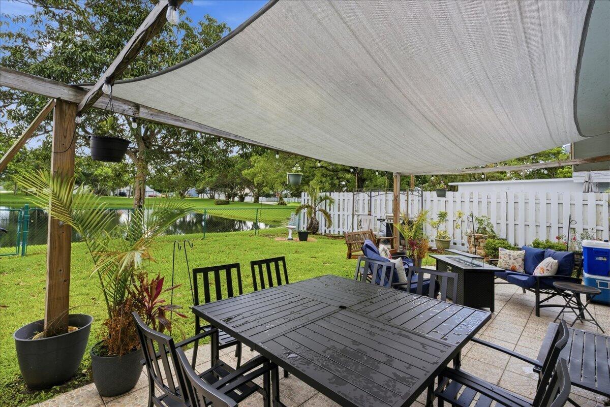 A patio features a dining set and lounge chairs under a large white shade sail — 970 SW 111th Way, Davie FL 33324, DAVIE, FL
