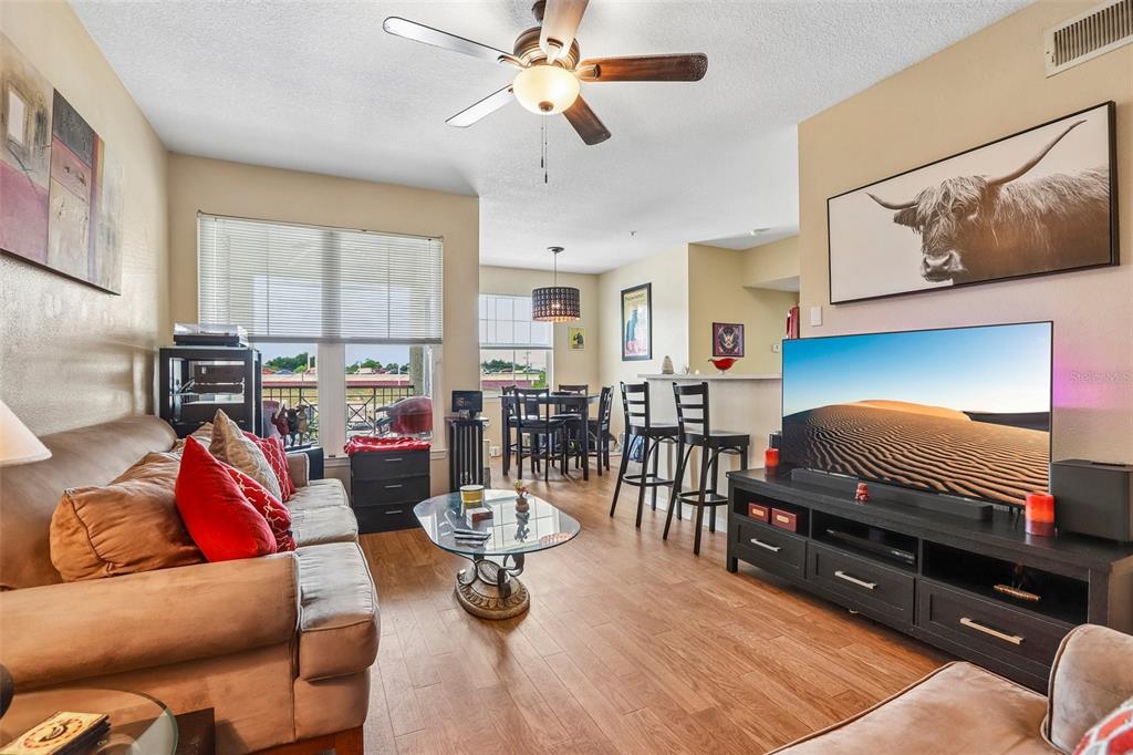 A living room with wood-look flooring, a ceiling fan, a sofa, and a television — 1810 E PALM AVENUE UNIT 5322, TAMPA, FL