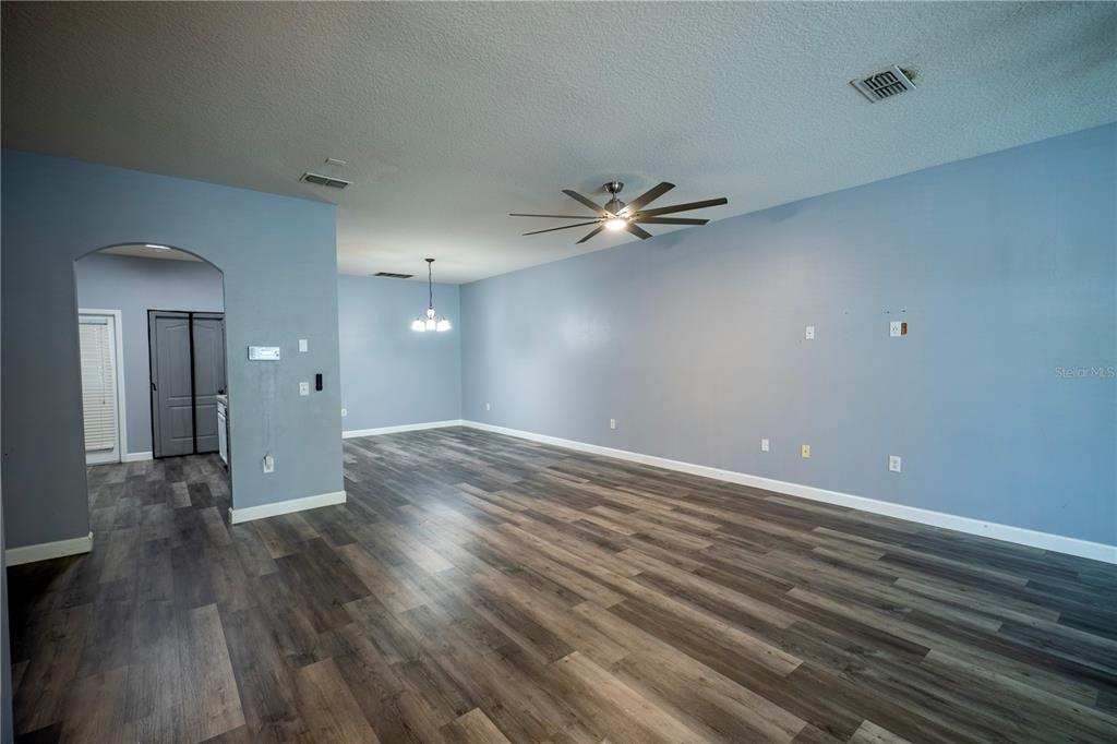 A spacious living room with light blue walls, a ceiling fan, and wood-look flooring — 2431 GRASMERE VIEW PARKWAY N, KISSIMMEE, FL
