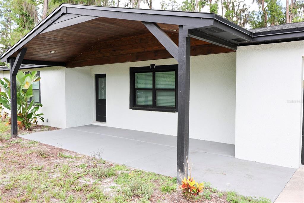 An aerial view of a house nestled in a wooded area beside a large lake — 730 CRYSTAL LAKE RD, LUTZ, FL