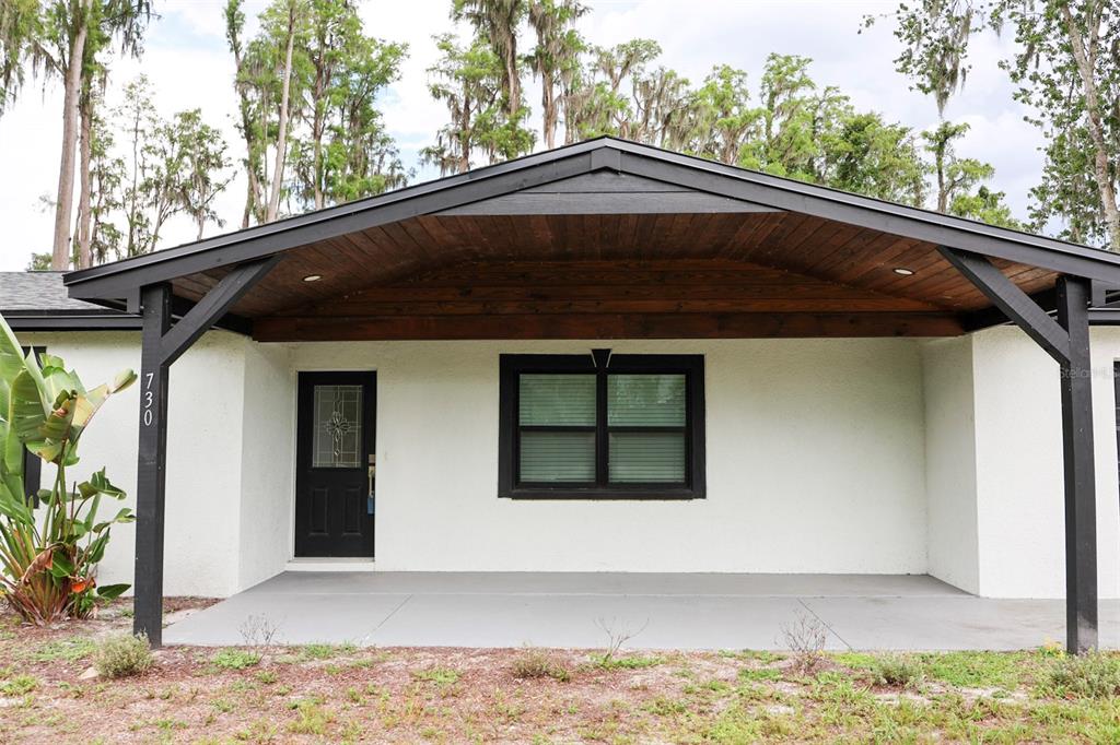 An aerial view shows a house with a driveway and a large, tree-filled backyard — 730 CRYSTAL LAKE RD, LUTZ, FL