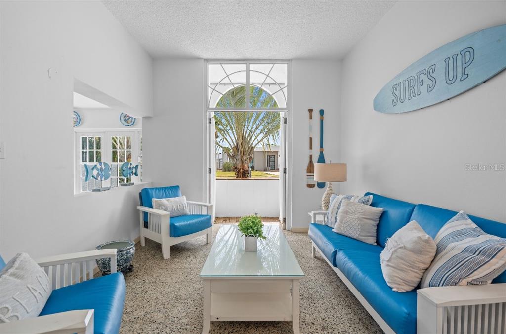 A living room features blue sofas, a glass coffee table, and a surfboard wall decoration — Calle 2 DORADO DEL MAR G8, DORADO, PR