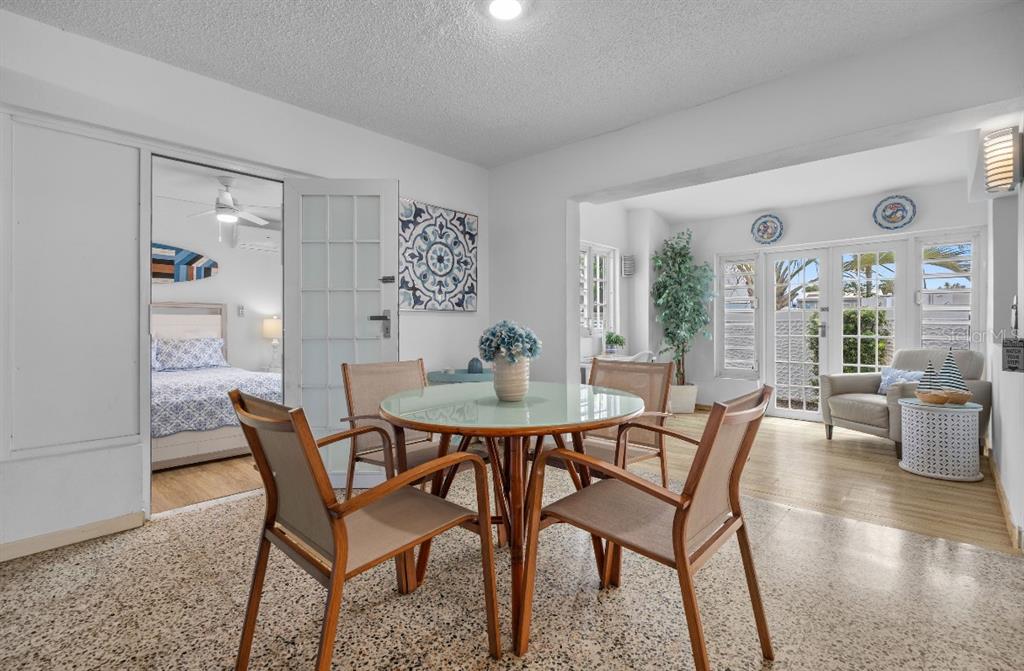 A dining area with a glass table and four chairs opens into a bedroom and sunroom — Calle 2 DORADO DEL MAR G8, DORADO, PR