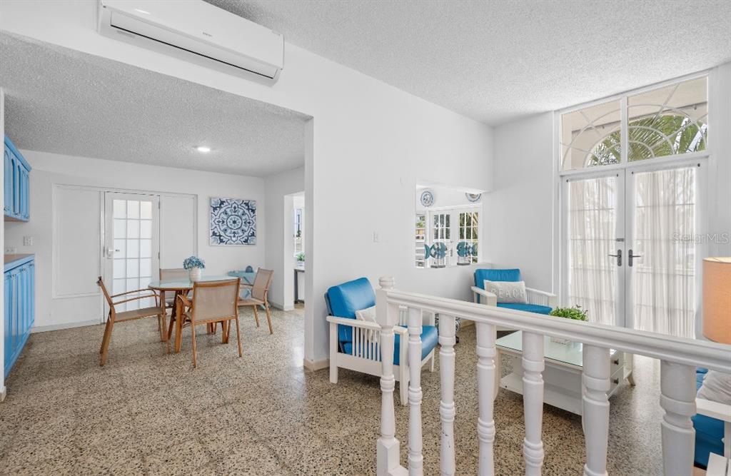 A bright living and dining area features white walls, terrazzo flooring, and blue furniture — Calle 2 DORADO DEL MAR G8, DORADO, PR