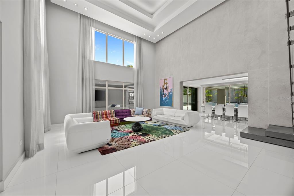 A spacious living room with high ceilings, white tile floors, and a colorful patterned rug — 442 DORADO BEACH EAST, DORADO, PR