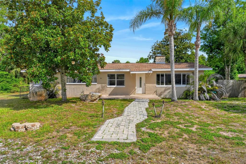 A single-story house with a tan exterior, a paved walkway, and palm trees in the yard — 71 FAIRVIEW AVENUE, ORMOND BEACH, FL