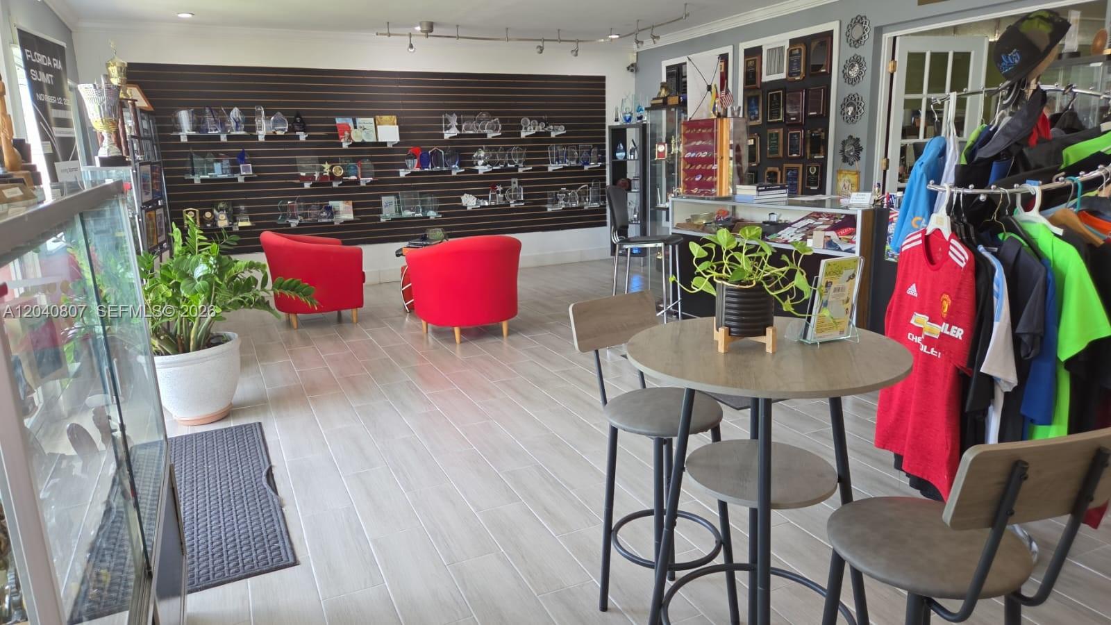 A commercial space features a trophy display wall, red armchairs, and a small seating area — 5824 Johnson St, Hollywood FL 33021, HOLLYWOOD, FL